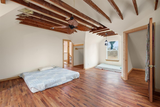 bedroom with lofted ceiling with beams and hardwood / wood-style floors