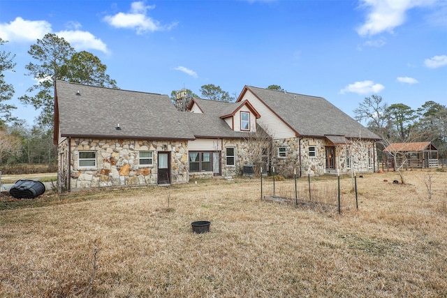 back of house with cooling unit and a lawn