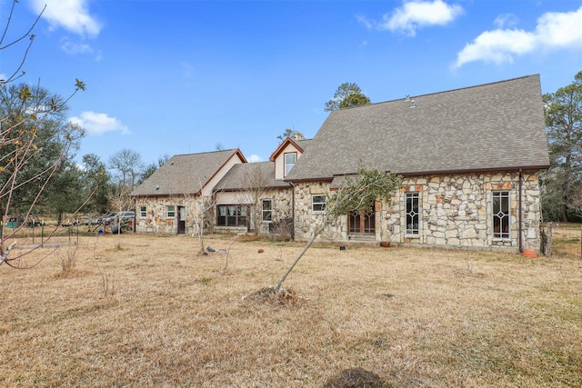 rear view of property featuring a lawn