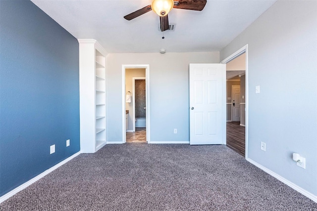 unfurnished bedroom featuring ceiling fan, ensuite bathroom, and dark carpet