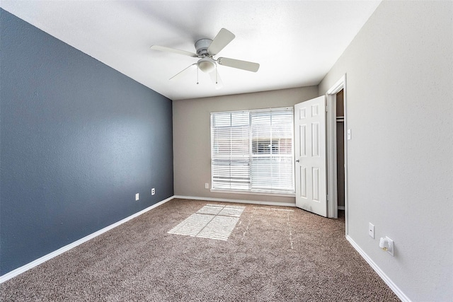 carpeted empty room featuring ceiling fan