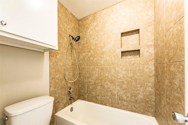 bathroom with tiled shower / bath combo and toilet