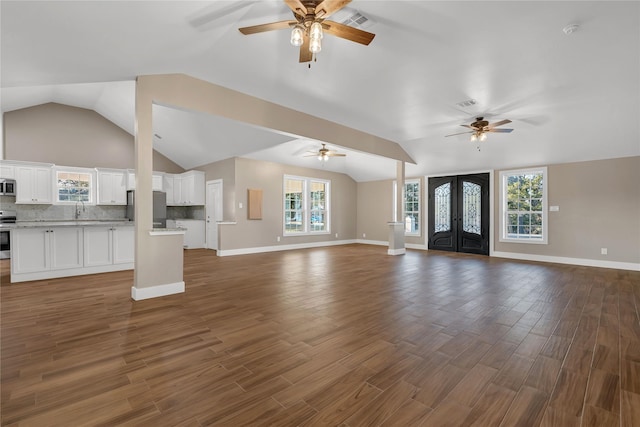 unfurnished living room featuring french doors, lofted ceiling, sink, and dark wood-type flooring