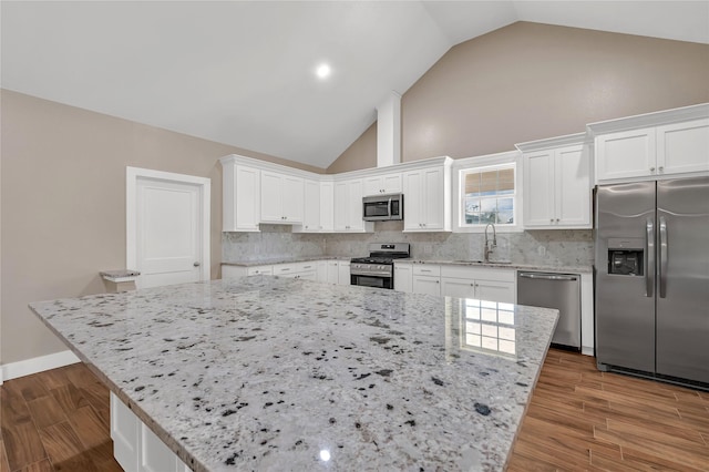 kitchen with sink, a center island, white cabinets, and appliances with stainless steel finishes