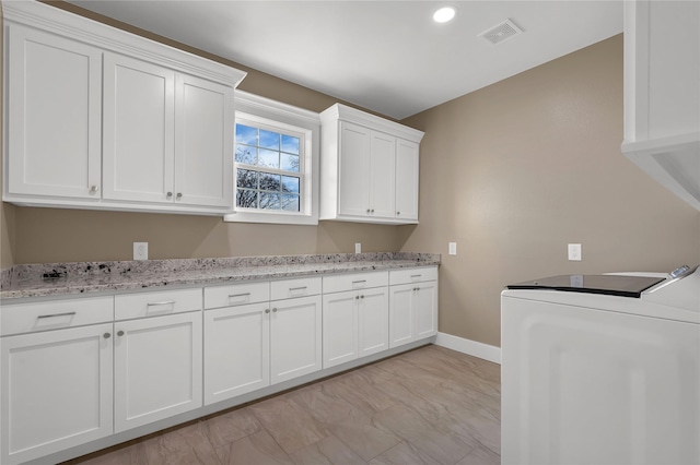 laundry room with cabinets and washer / dryer