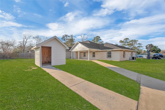 single story home featuring a front yard, central AC unit, and a shed