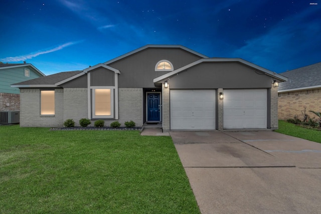 ranch-style house with a garage, a front lawn, and central air condition unit