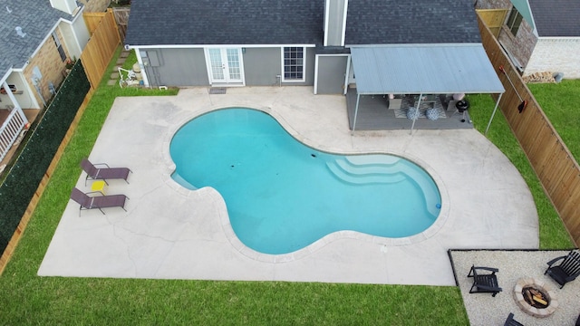 view of pool with a fire pit, a patio, and french doors