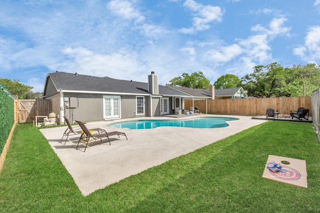 view of pool with a yard, a patio area, and french doors