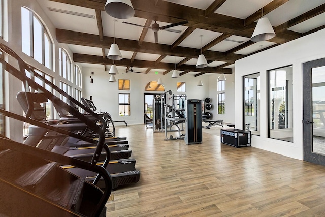 gym with light wood-type flooring, baseboards, and visible vents