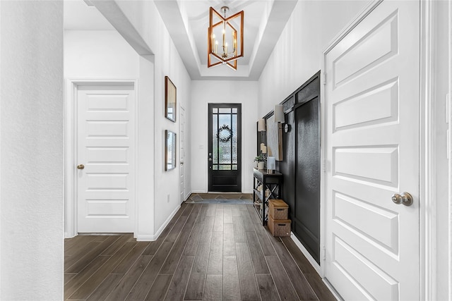 foyer entrance featuring an inviting chandelier and dark hardwood / wood-style flooring