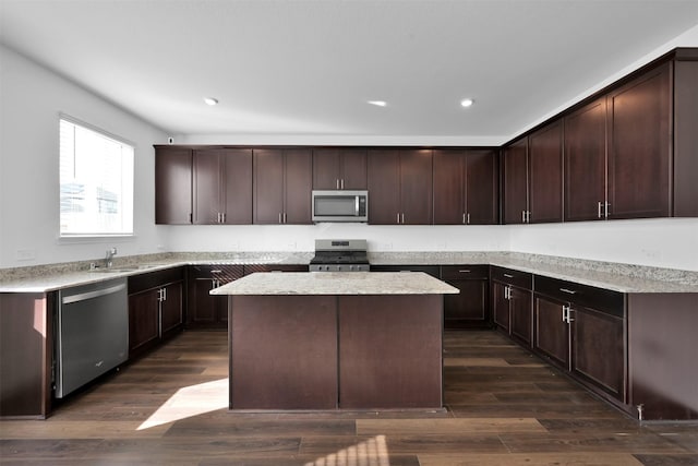 kitchen featuring stainless steel appliances, a center island, dark brown cabinets, and dark hardwood / wood-style flooring