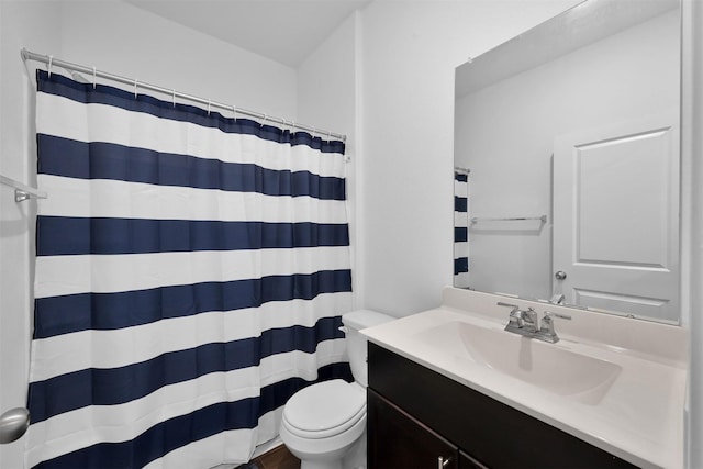 bathroom featuring vanity, walk in shower, and toilet