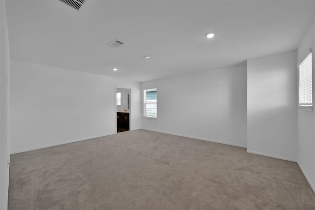 carpeted spare room featuring a healthy amount of sunlight