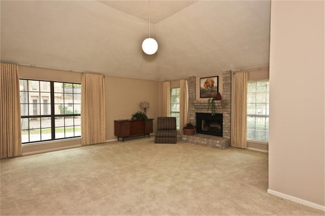 unfurnished living room with a brick fireplace, carpet floors, and vaulted ceiling