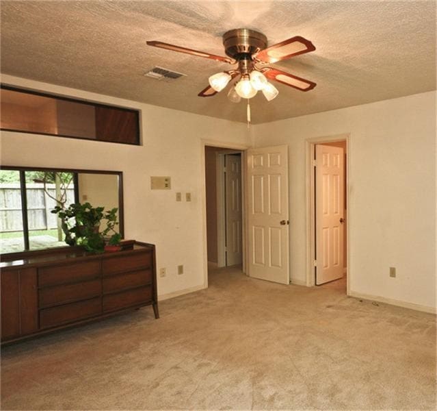 bedroom featuring light carpet and a textured ceiling