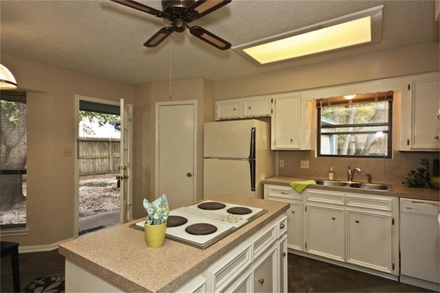 kitchen with white cabinetry, white appliances, a healthy amount of sunlight, and sink