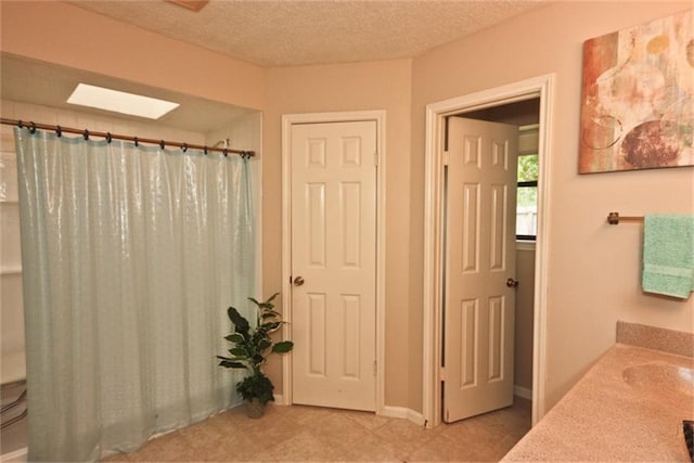 bathroom featuring vanity, a shower with curtain, and a textured ceiling