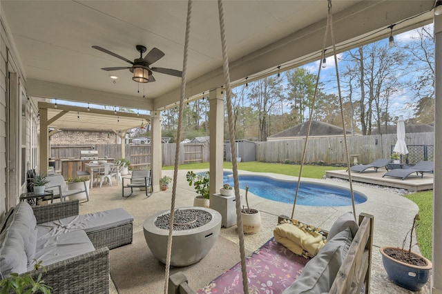 view of swimming pool with an outdoor living space with a fire pit, a patio, and ceiling fan