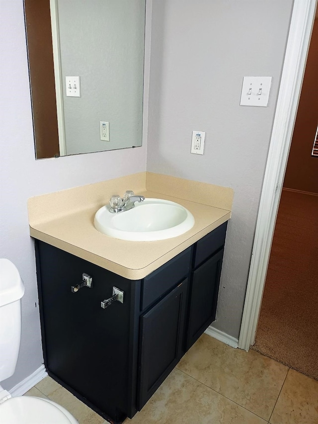 bathroom with tile patterned flooring, vanity, and toilet