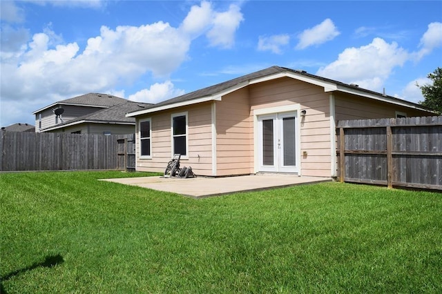 back of property with a yard, a patio, and french doors