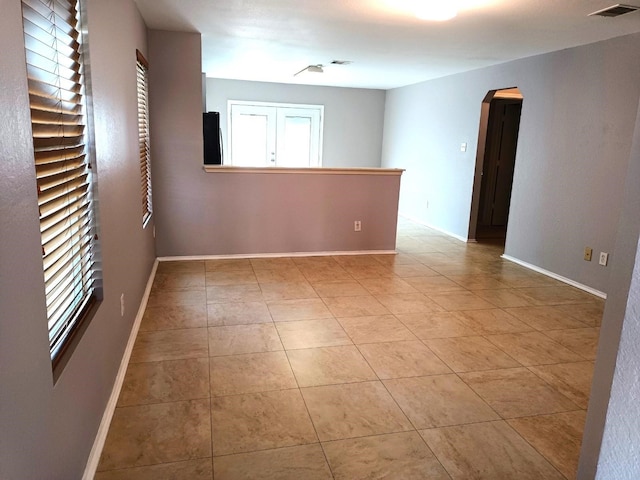 unfurnished room featuring light tile patterned flooring and a wealth of natural light