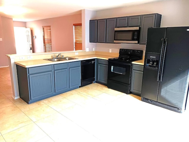 kitchen with light tile patterned floors, kitchen peninsula, sink, and black appliances