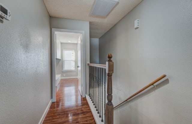 hall with dark hardwood / wood-style flooring and a textured ceiling