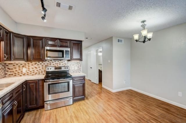 kitchen featuring an inviting chandelier, dark brown cabinets, stainless steel appliances, light hardwood / wood-style floors, and decorative backsplash