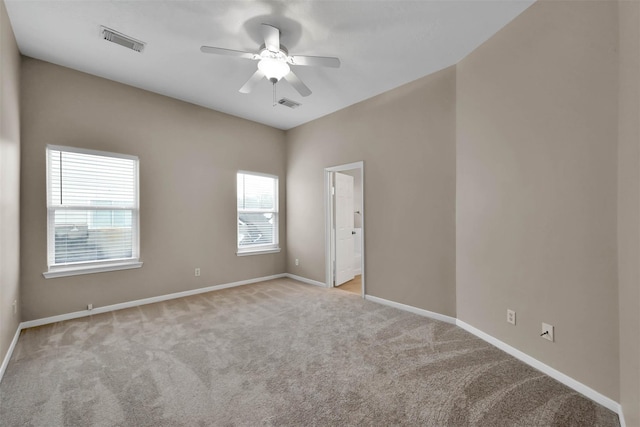 carpeted spare room featuring ceiling fan