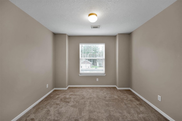 unfurnished room with light colored carpet and a textured ceiling