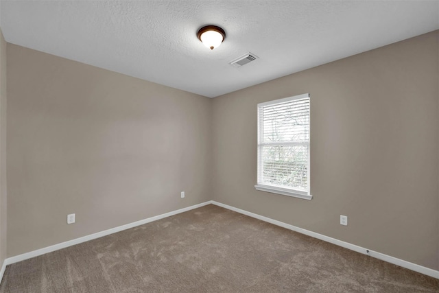 carpeted spare room featuring a textured ceiling