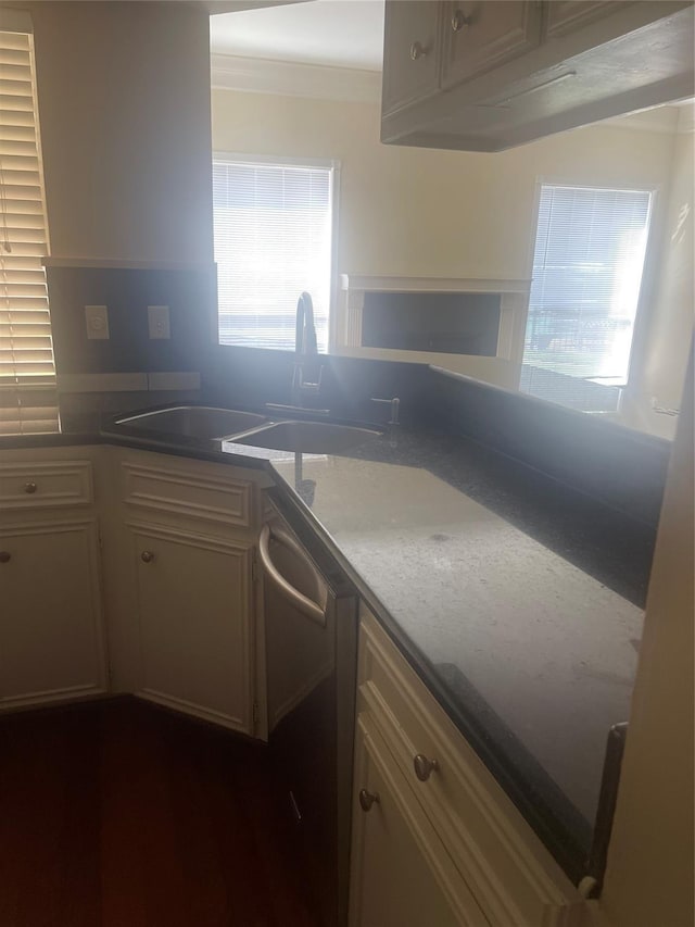 kitchen with dishwasher, light stone countertops, sink, and crown molding