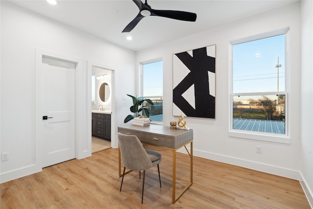 home office featuring sink, light hardwood / wood-style flooring, and ceiling fan