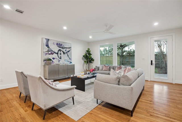 living room featuring ceiling fan, a wealth of natural light, and light hardwood / wood-style floors