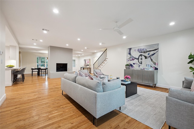 living room featuring ceiling fan and light wood-type flooring