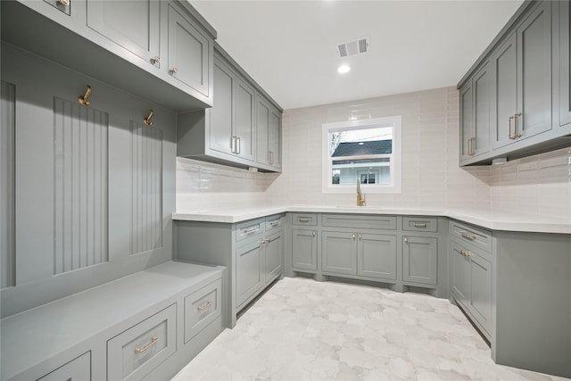 kitchen with sink, decorative backsplash, and gray cabinets