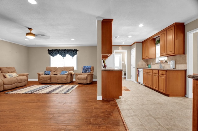 kitchen with sink, backsplash, ornamental molding, and stainless steel dishwasher