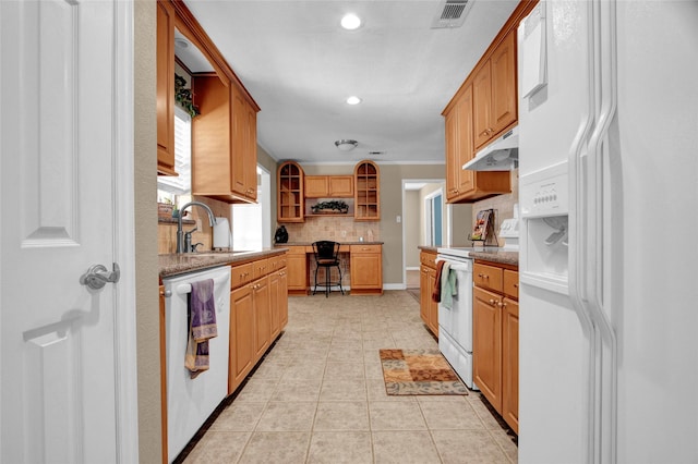 kitchen featuring sink, crown molding, white appliances, light tile patterned floors, and decorative backsplash