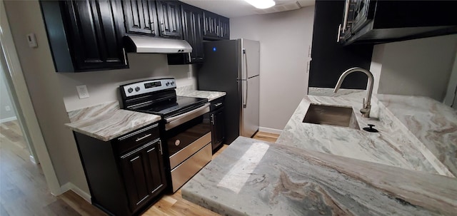 kitchen featuring sink, light hardwood / wood-style flooring, stainless steel appliances, and light stone countertops