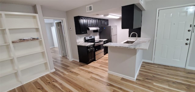 kitchen featuring stainless steel appliances, light stone countertops, sink, and light wood-type flooring