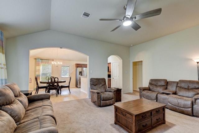 living room featuring light carpet, ceiling fan with notable chandelier, and vaulted ceiling