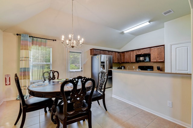 dining area featuring lofted ceiling, light tile patterned floors, and a chandelier