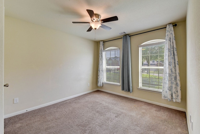 carpeted spare room with ceiling fan