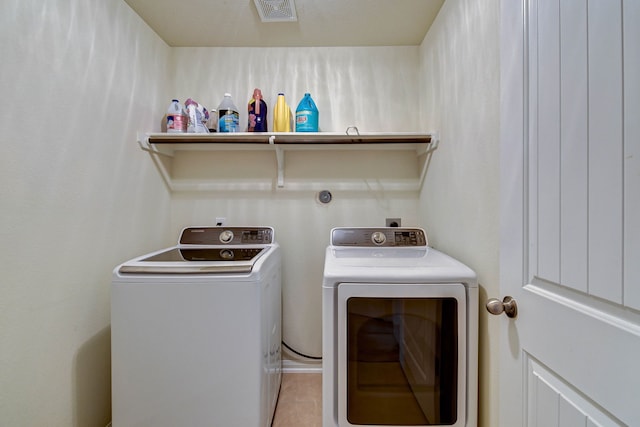 laundry room featuring washer and clothes dryer and light tile patterned floors