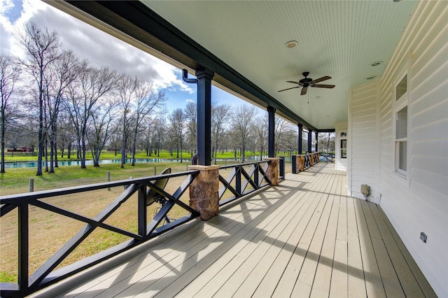 deck featuring a water view, ceiling fan, and a porch