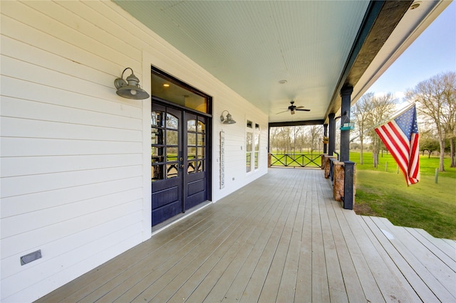 deck featuring a lawn, french doors, ceiling fan, and a porch