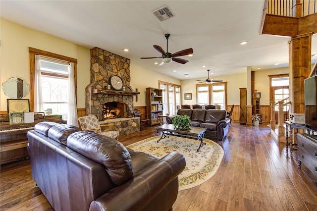 living room featuring wood-type flooring and a stone fireplace