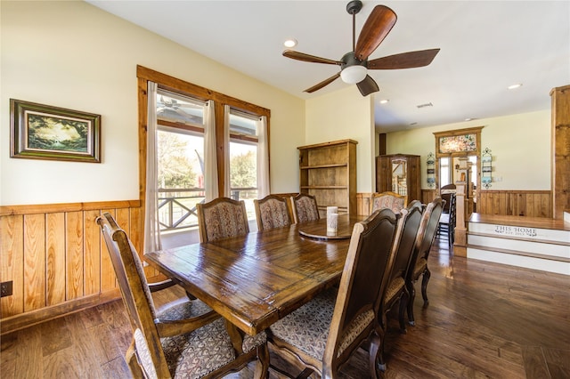 dining area with wooden walls, dark hardwood / wood-style floors, and ceiling fan