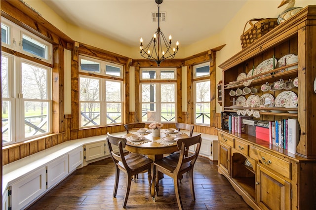 dining space with a notable chandelier and dark hardwood / wood-style flooring